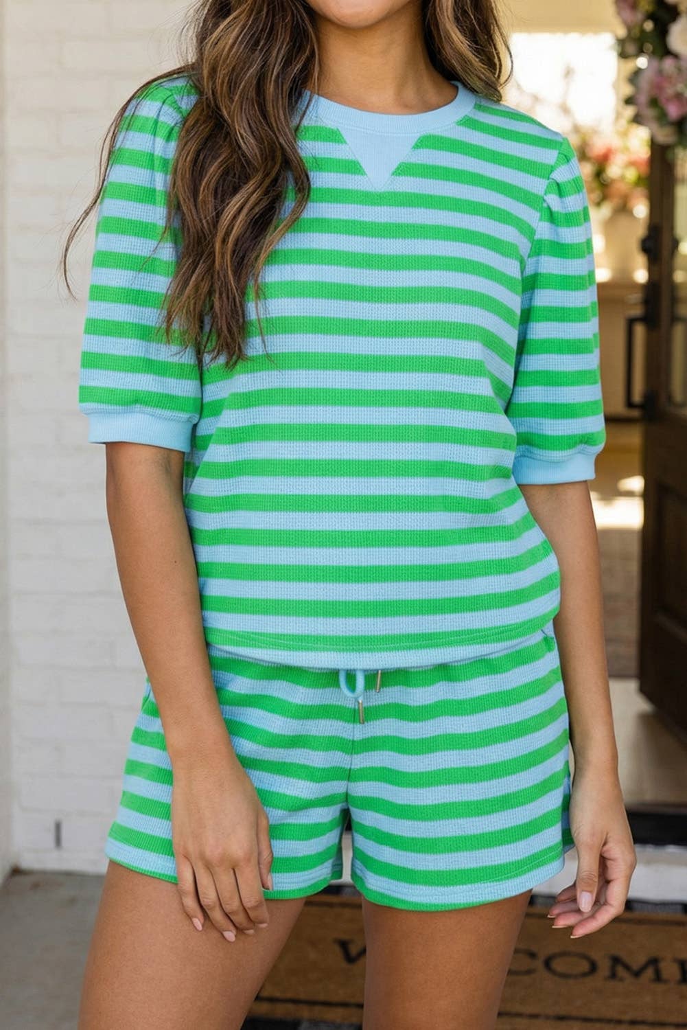 Person wearing a green and white striped outfit indoors.
