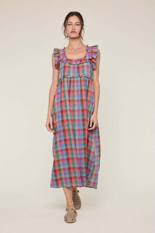Woman wearing a plaid dress with ruffled sleeves on a beige background