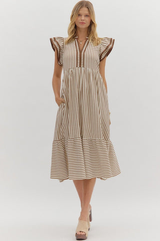 Woman wearing a striped dress with ruffled sleeves on a white background