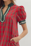 Red plaid dress with green and white trim on a plain background