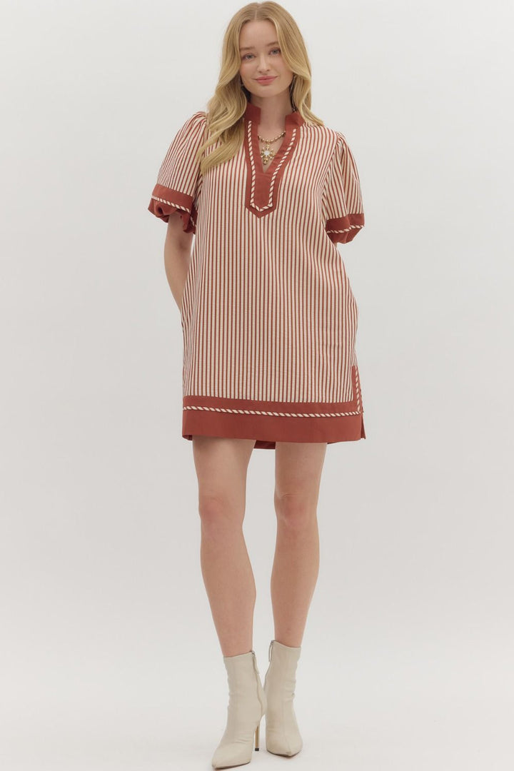 Woman wearing a striped dress with a plain background