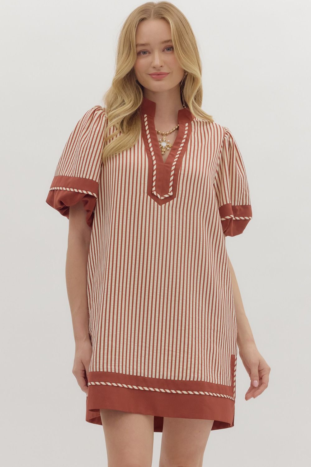 Woman wearing a striped dress with red accents on a white background