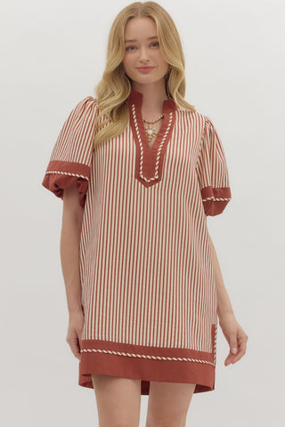 Woman wearing a striped dress with red accents on a white background