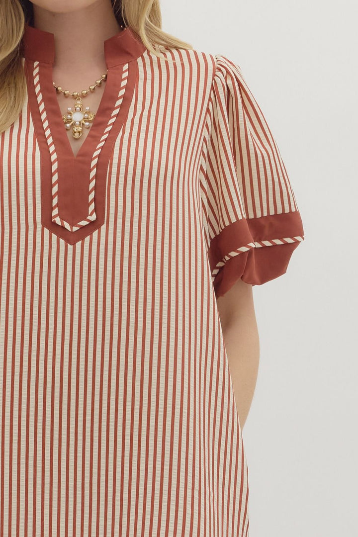 Red and white striped dress with a close-up of the neckline on a plain background