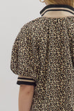 Leopard print shirt with black trim on a plain background