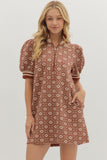 Woman wearing a patterned dress on a plain background