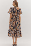 Woman wearing a patterned dress on a plain background