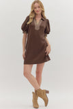 Woman wearing a brown dress with plaid accents on a white background