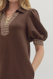 Brown dress with plaid trim on a plain background