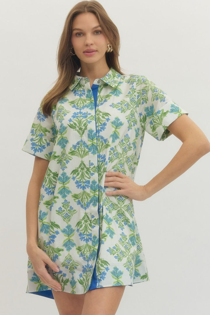 Woman wearing a floral shirt dress on a white background