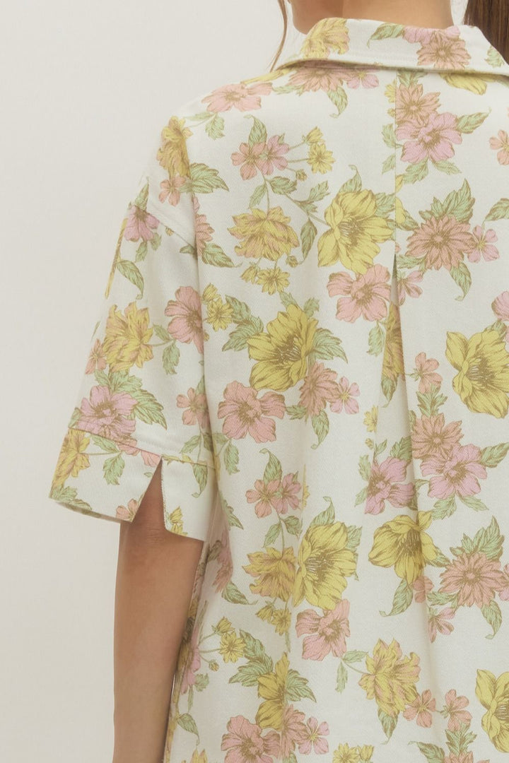 Floral patterned shirt with yellow and pink flowers on a plain background