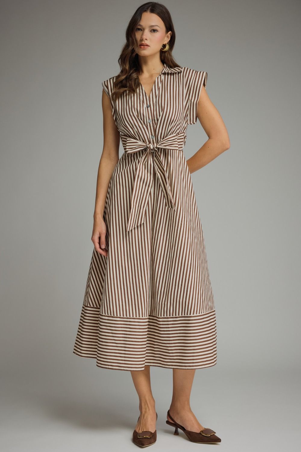 Woman wearing a striped dress against a gray background