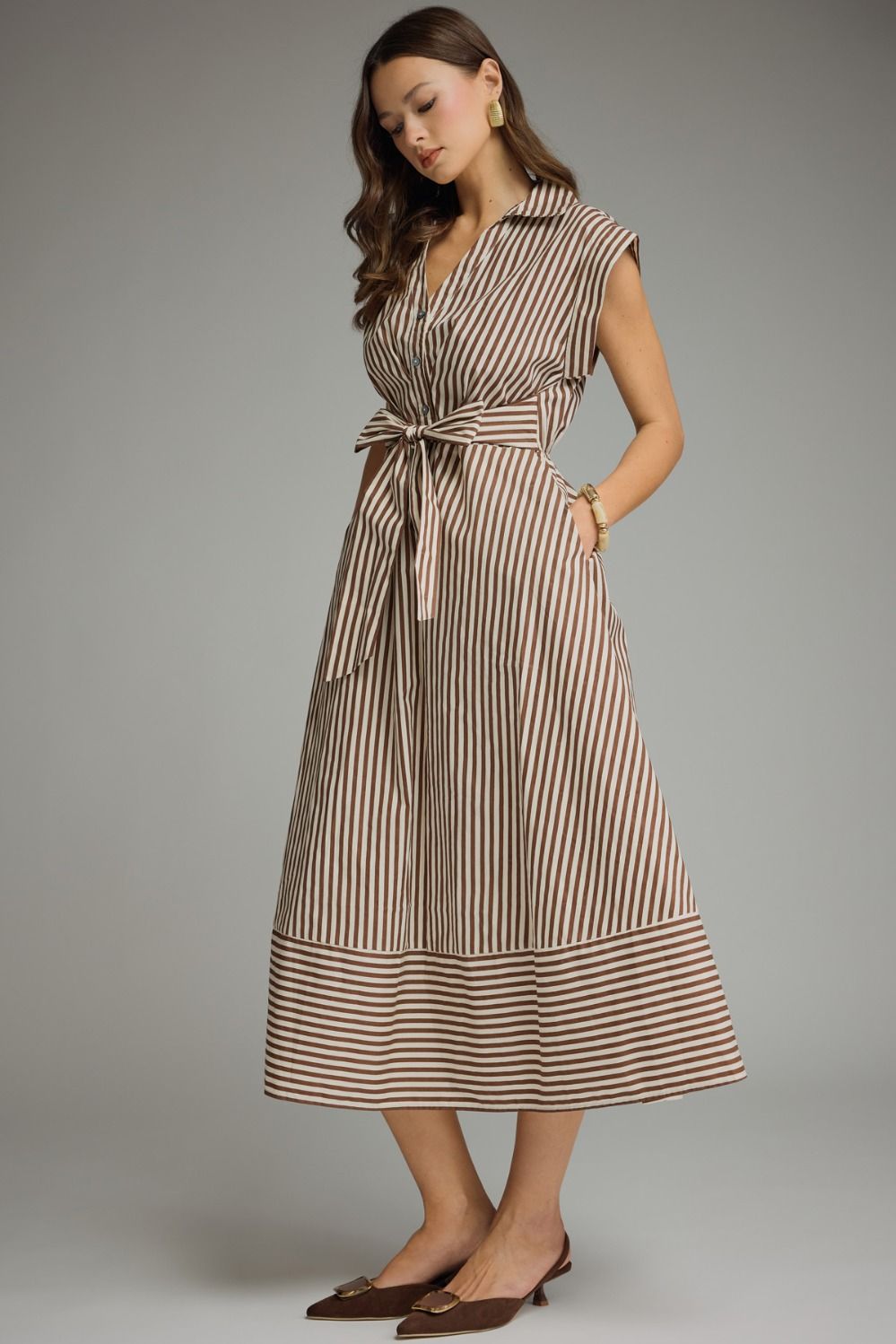 Woman wearing a striped dress against a gray background