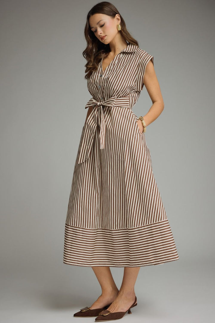 Woman wearing a striped dress against a gray background