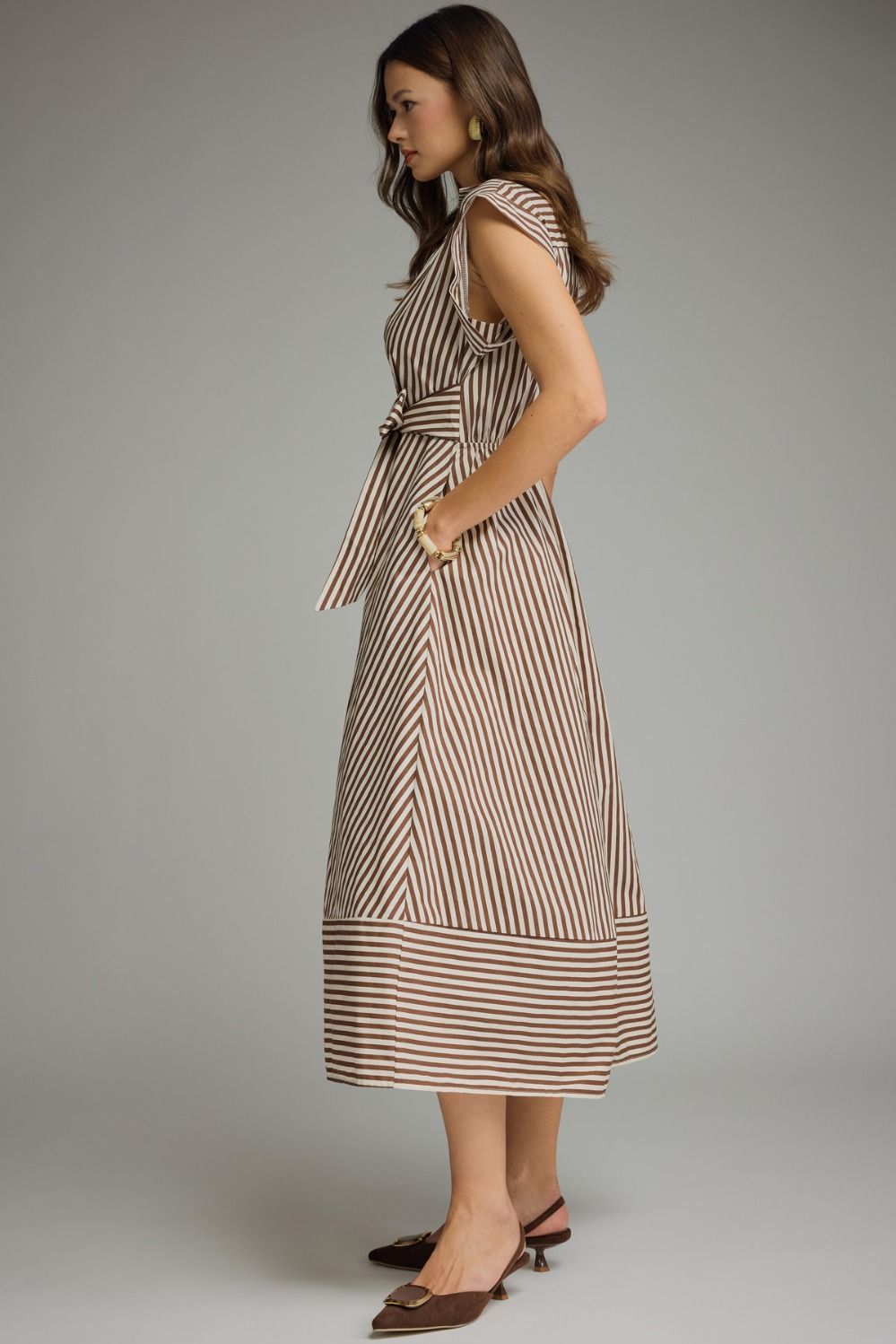 Woman wearing a striped dress against a gray background