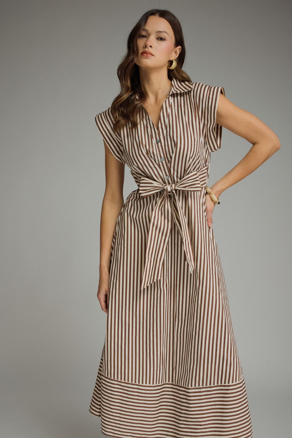 Woman wearing a striped dress against a gray background