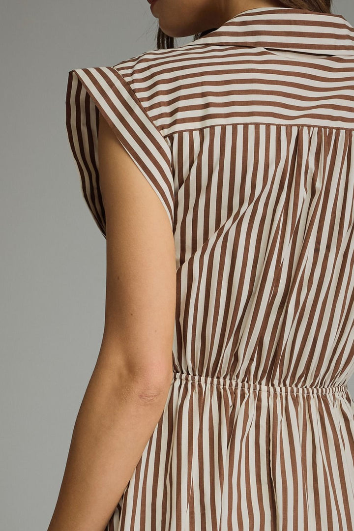 Close-up back view of a person wearing a sleeveless dress with vertical brown and cream stripes and a gathered waist.