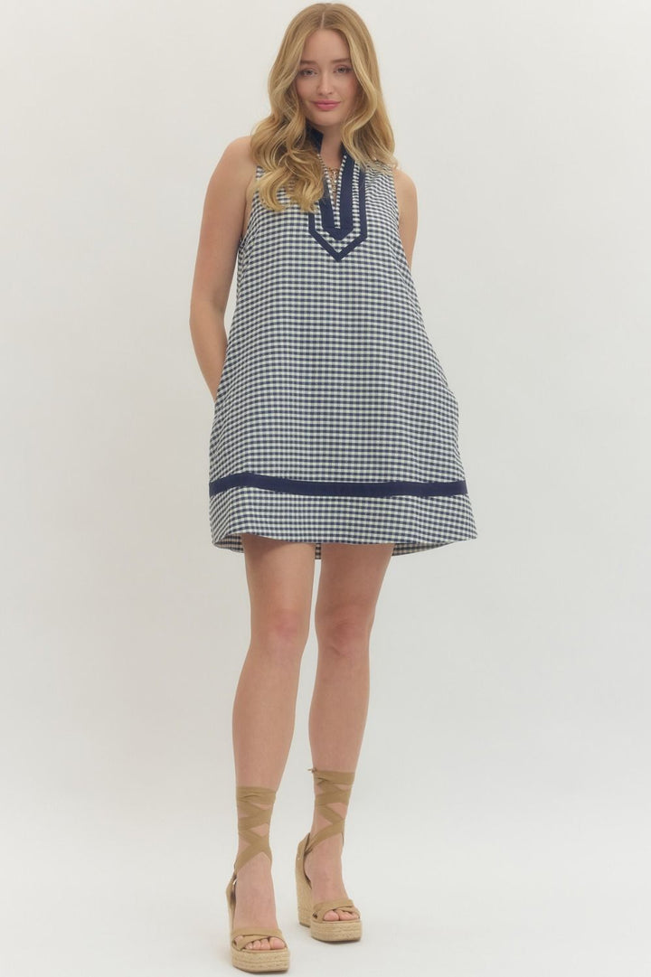 Woman wearing a checkered dress with a blue accent on a white background