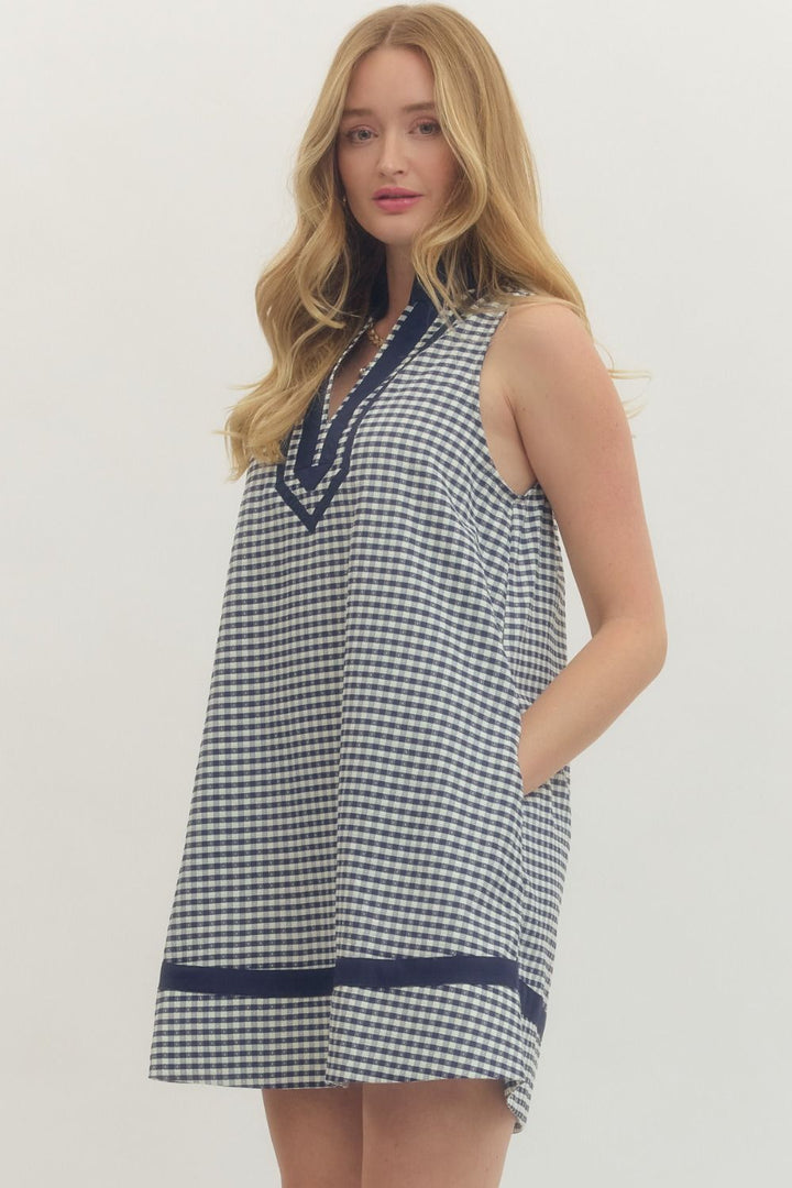 Woman wearing a blue and white checkered dress with a white background