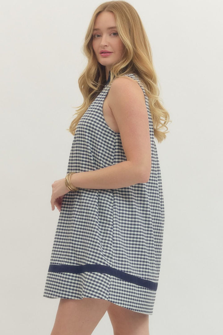 Woman wearing a checkered dress with a plain background