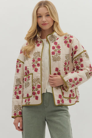 Woman wearing a floral embroidered jacket on a plain background