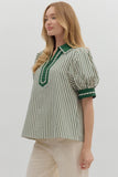 Woman wearing a green and white striped blouse with a plain background