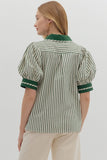 Woman wearing a green and white striped shirt with puff sleeves on a plain background