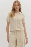 Woman wearing a cream-colored knitted top and beige pants on a white background