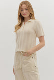 Woman wearing a beige knitted top and pants on a plain background