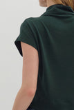 Green polo shirt worn by a person on a light gray background