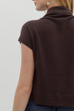 Brown short-sleeve top worn by a person on a light gray background