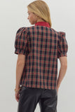 Person wearing a plaid shirt with puff sleeves on a plain background