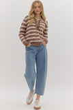 Woman wearing a striped sweater and blue jeans on a white background