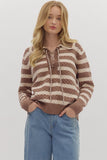 Woman wearing a brown and beige striped sweater with a white background
