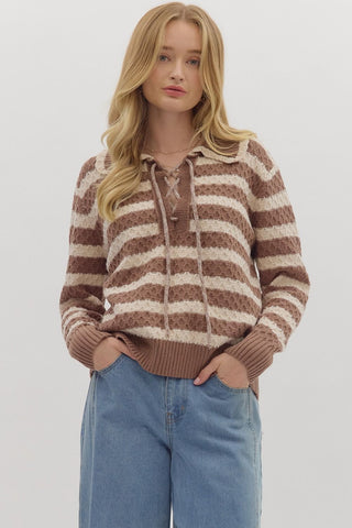 Woman wearing a brown and beige striped sweater with a white background