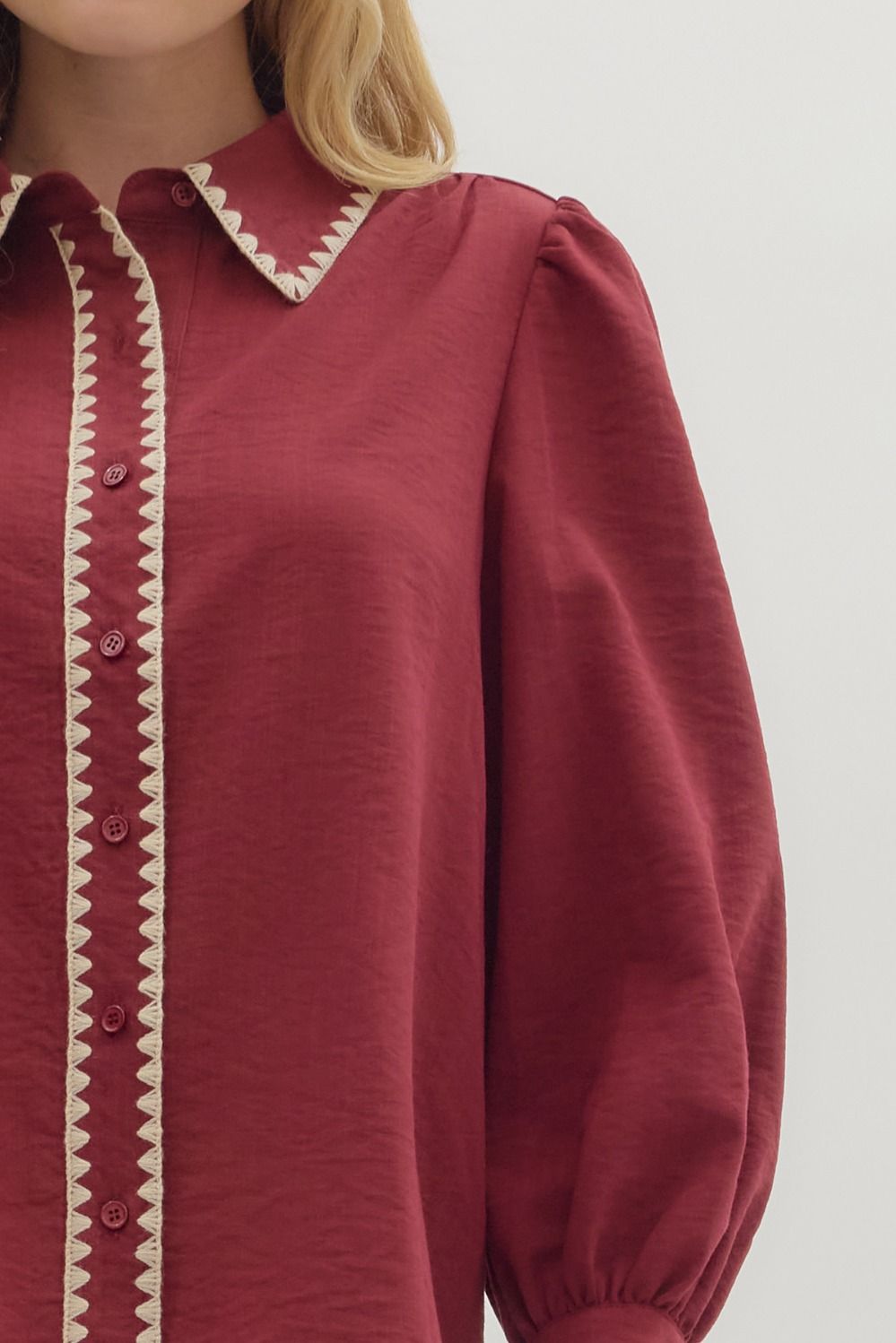 Red blouse with white trim on a plain background