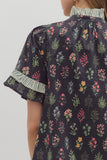 Floral patterned shirt with ruffled sleeves on a plain background
