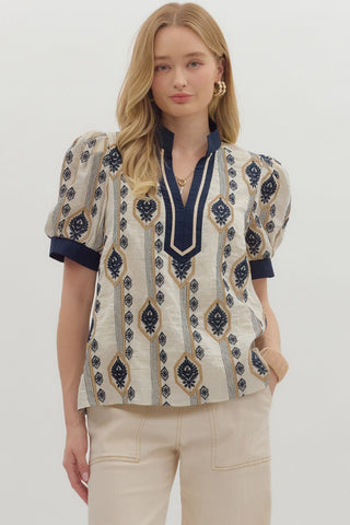 Woman wearing a patterned blouse with puff sleeves on a white background