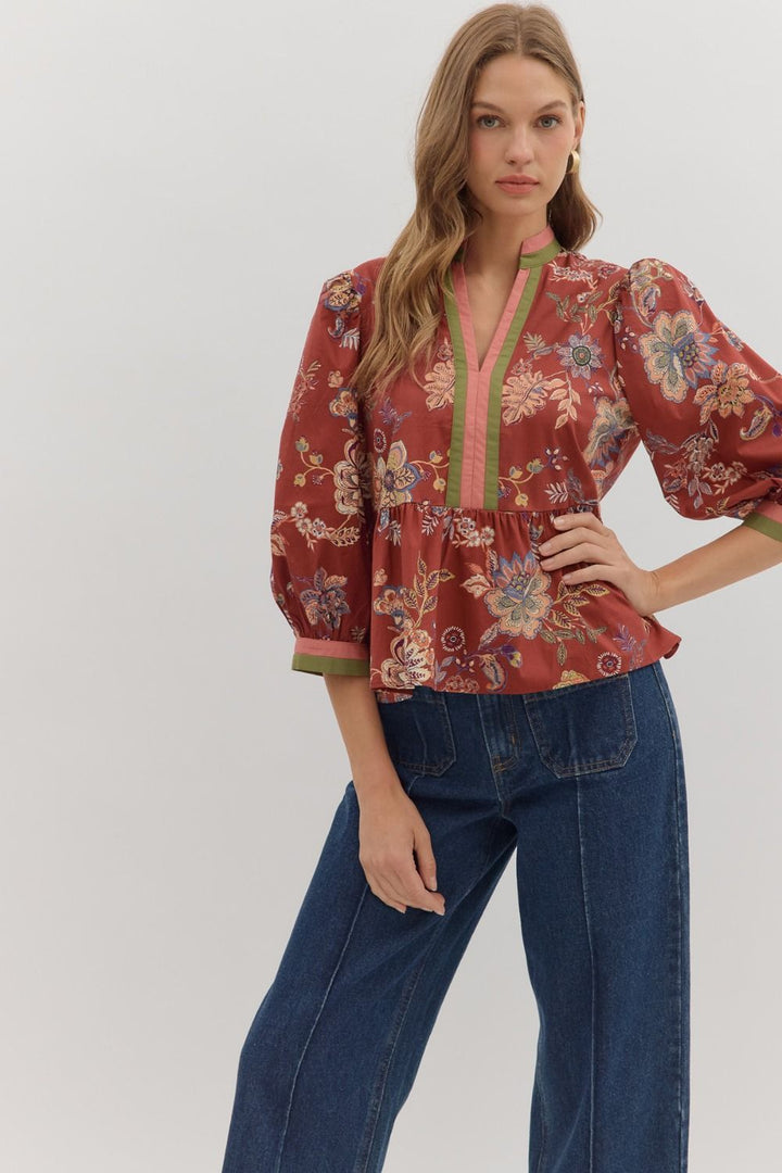 Woman wearing a floral blouse and blue jeans on a white background