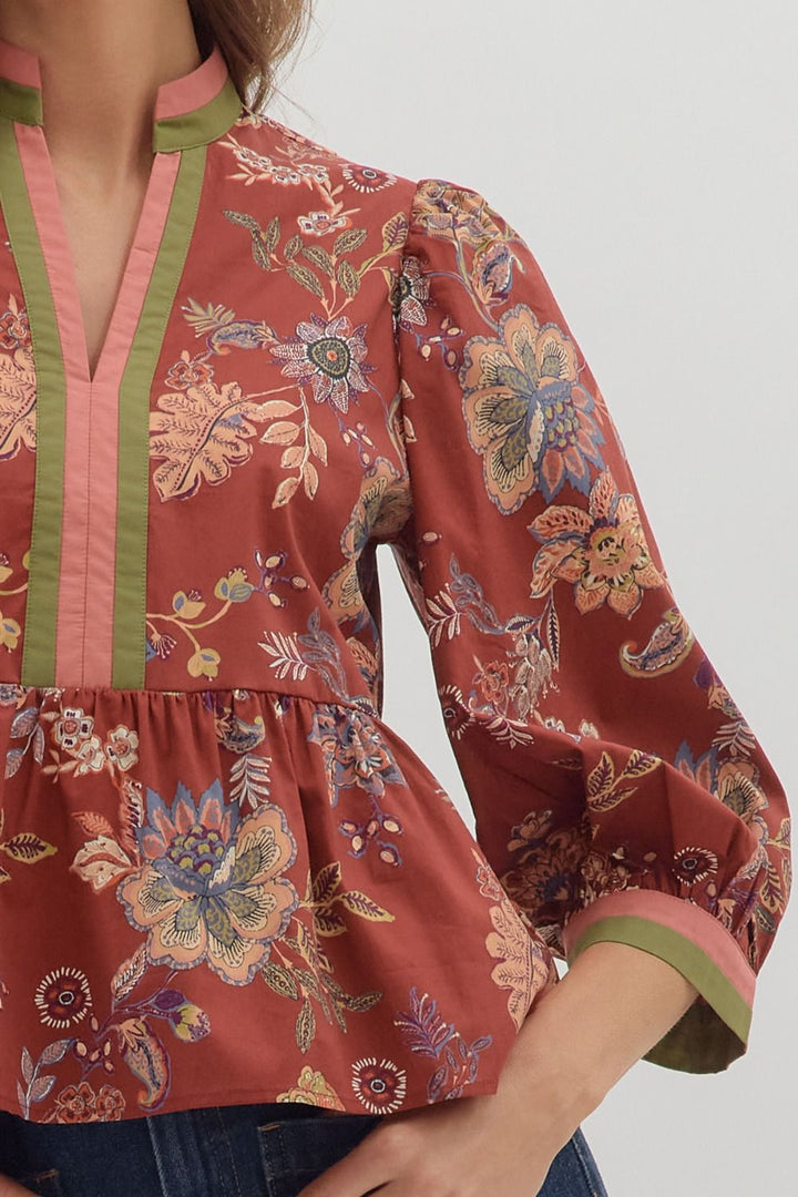 Floral patterned blouse with green accents on a plain background