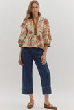 Woman wearing a floral blouse and blue jeans on a white background