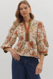 Woman wearing a floral blouse with a plain background
