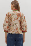 Woman wearing a floral blouse with a plain background