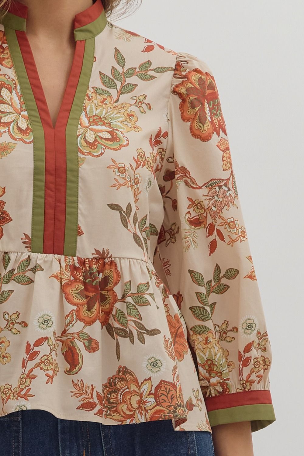 Floral patterned blouse with red and green accents on a plain background