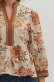 Floral patterned blouse with red and green accents on a plain background
