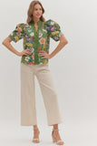 Woman wearing a floral blouse and beige pants on a white background