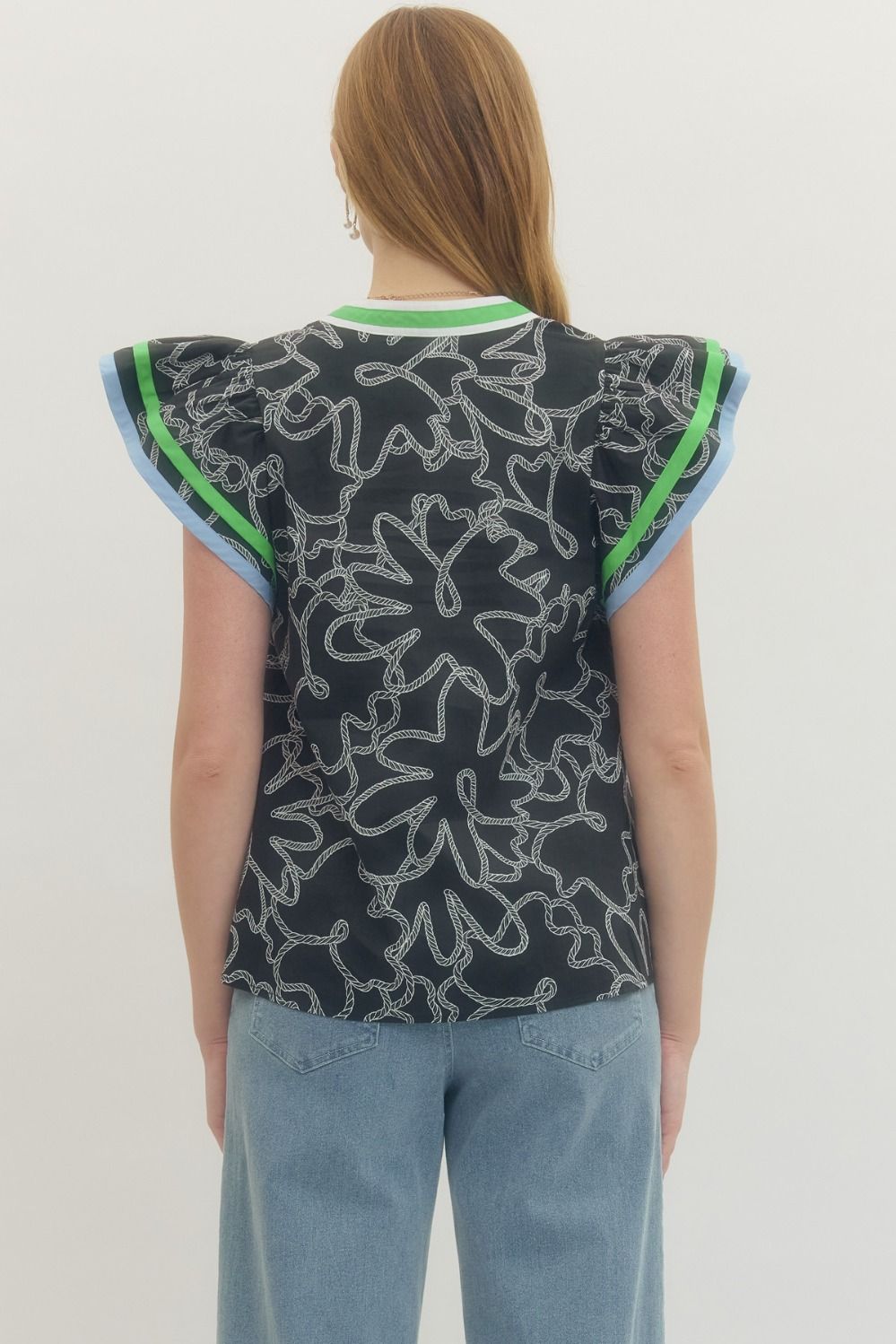Person wearing a sleeveless top with a floral pattern on a plain background