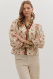 Woman wearing a floral blouse with green accents on a white background