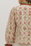 Floral patterned blouse with long sleeves on a plain background
