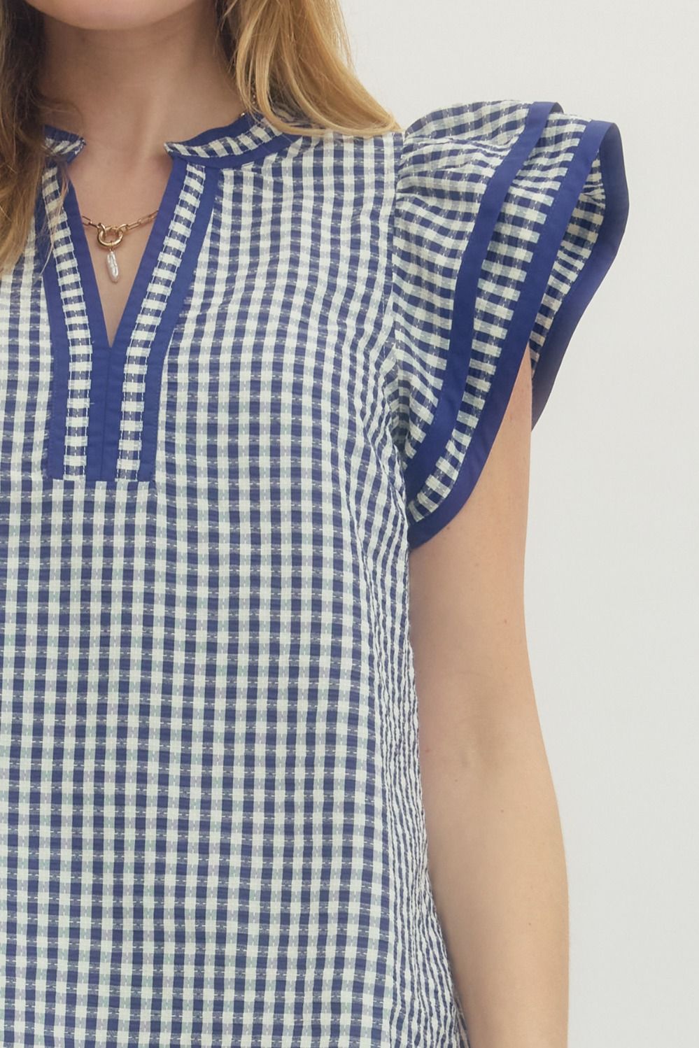 Blue and white checkered dress with puffed sleeves on a plain background